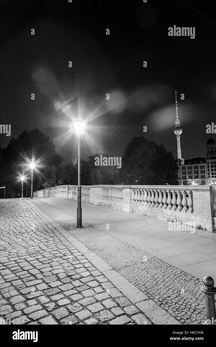 Vue d'un pont pedestiran tard dans la nuit à Berlin, avec l'emblématique Fernsehturm en arrière-plan. Banque D'Images