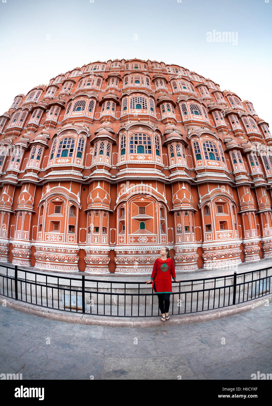 Femme en robe rouge avec écharpe debout près de façade de Hawa Mahal, Rajasthan, Inde Banque D'Images