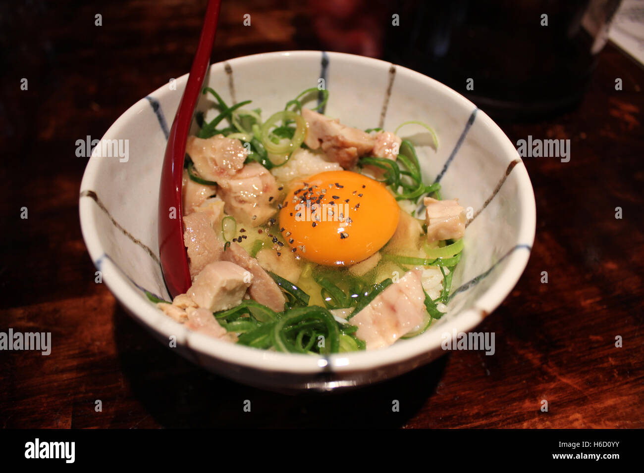 Riz japonais avec du poulet, l'oignon vert et l'oeuf cru sur le dessus au restaurant à Kyoto, Japon Banque D'Images