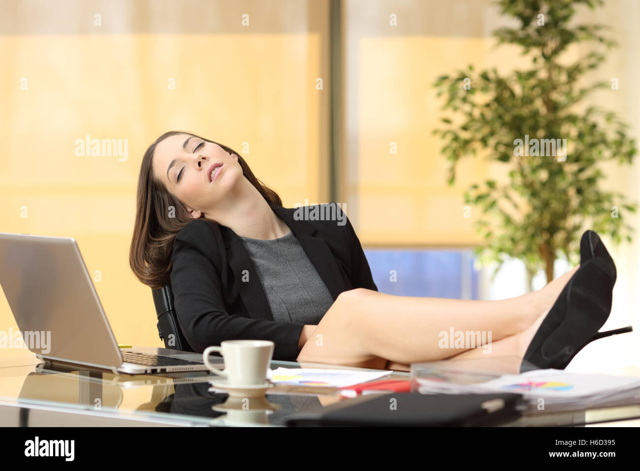 Paresseux ou fatigué businesswoman dormir au travail avec les jambes sur la table at office Banque D'Images