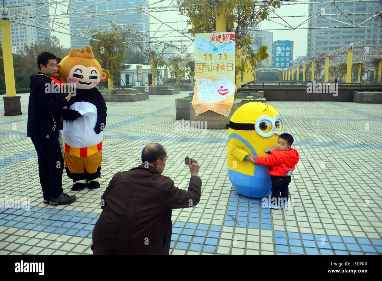 Linyi, Linyi, Chine. 17 novembre, 2016. Qingdao, Chine-Novembre 17 2016 : (usage éditorial uniquement. Chine).Un student wearing costume de câlins avec un jaune Minion kid pendant une activité de bienfaisance à la Place du Peuple à Shanghai, la Chine de l'est la province de Shandong, 17 novembre 2016, marquant la Journée mondiale Bonjour. Bonjour le monde séculier est un jour férié observé chaque année le 21 novembre, pour exprimer que les conflits doivent être résolus par la communication plutôt que l'usage de la force. Saluez verbalement les participants dix personnes ou plus à ce jour en tant qu'expression de l'importance de pers Banque D'Images