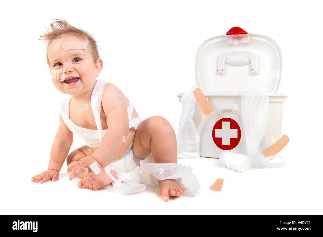 Mignon Bébé Garçon jouant avec des bandages dans une trousse de premiers soins. Banque D'Images