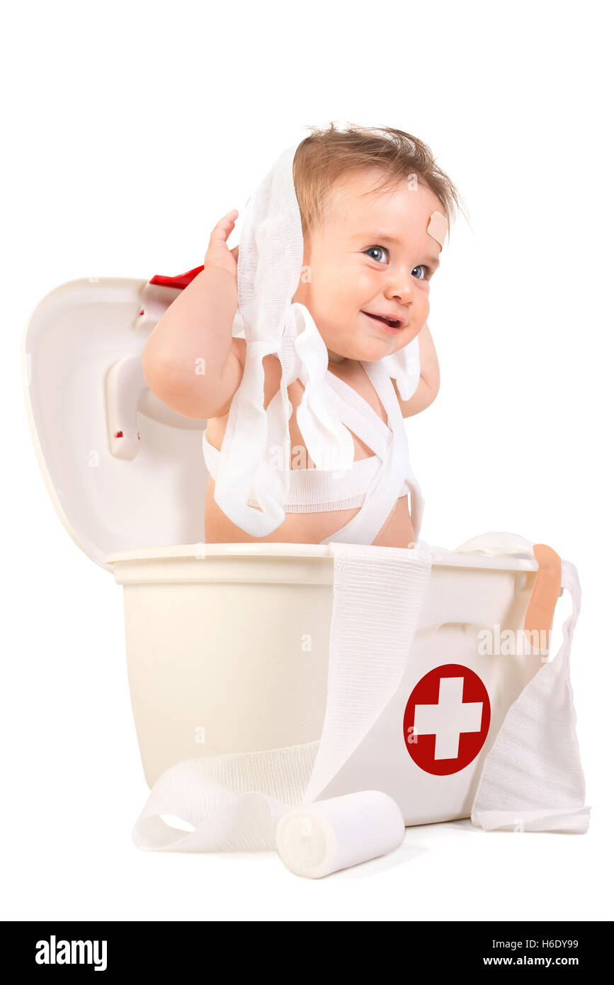 Mignon Bébé Garçon jouant avec des bandages dans une trousse de premiers soins. Banque D'Images