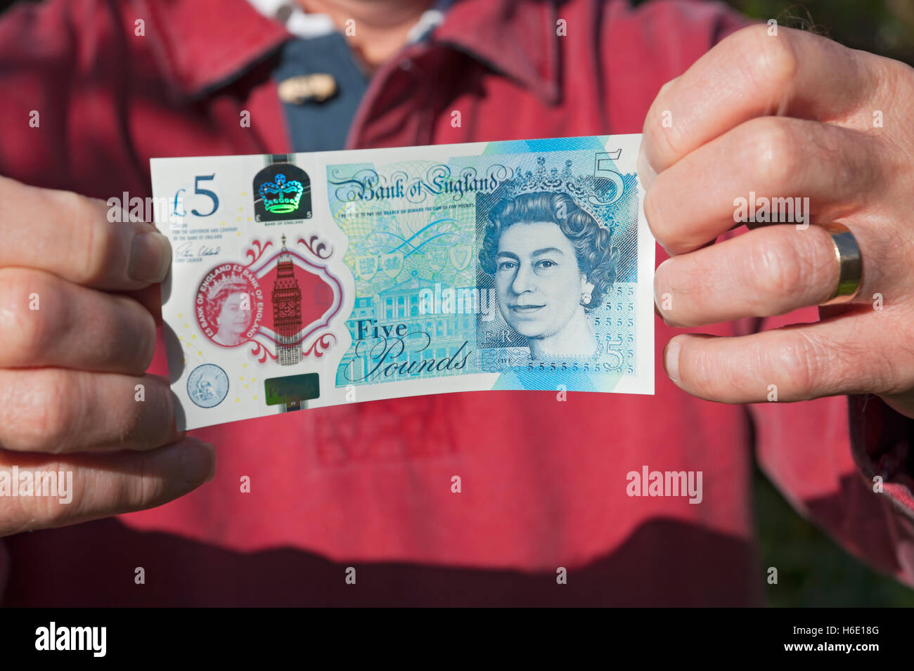 Gros plan de billet d'argent anglais personne homme tenant un nouveau polymère billet de cinq livres £ 5 livres cash England UK Royaume-Uni GB Grande-Bretagne Banque D'Images