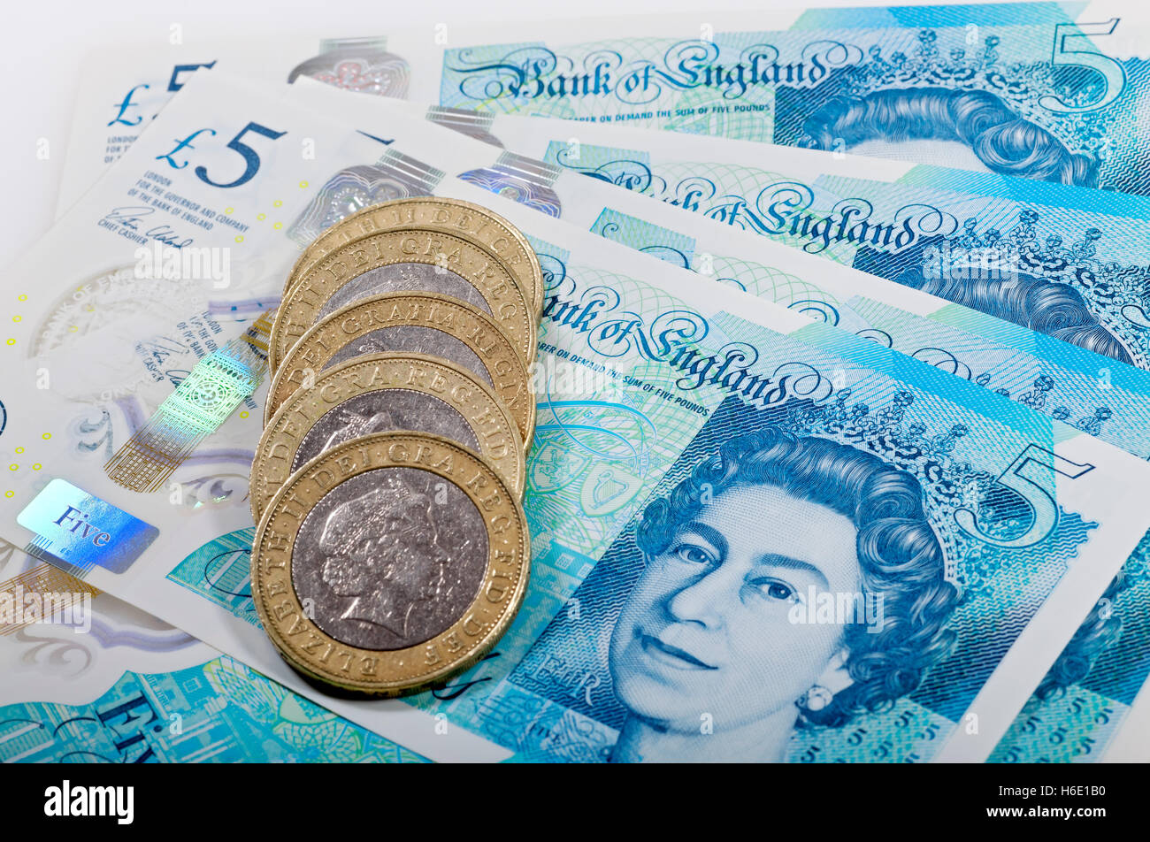 Gros plan de Queen Elizabeth argent anglais £5 nouveau polymère billets de banque de cinq livres et deux livres pièces de monnaie cash finance concept Angleterre Royaume-Uni Grande-Bretagne Banque D'Images