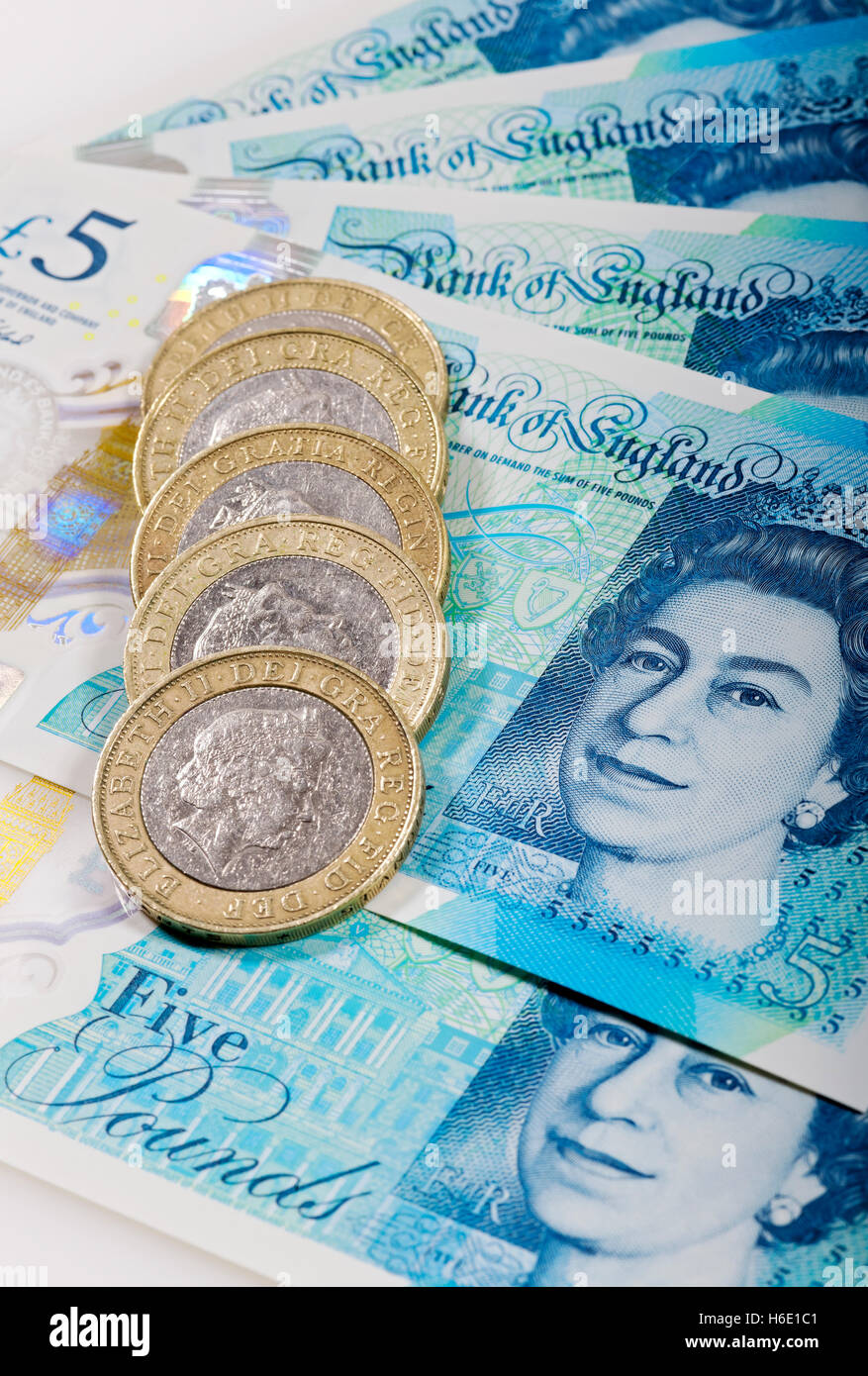 Gros plan de l'argent anglais cash nouveau polymère billets de cinq livres et deux livres pièces de monnaie financement concept Angleterre Royaume-Uni GB Grande-Bretagne Banque D'Images