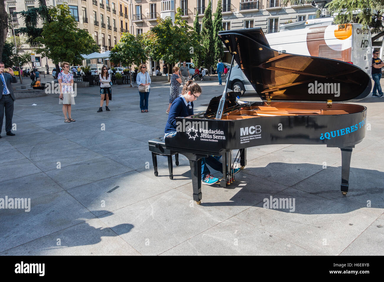 Une femme joue du piano pianiste devant de nombreuses aux curieux pendant plein de pianos à Madrid Madrid, Espagne. Banque D'Images