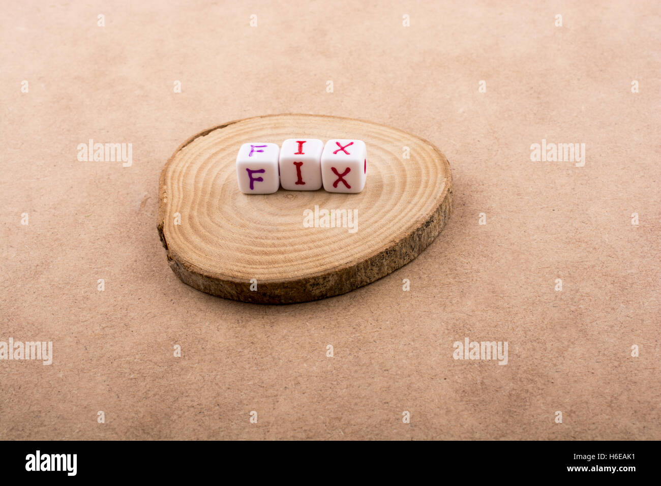 Lettre de l'alphabet coloré cubes dans un morceau en bois Banque D'Images