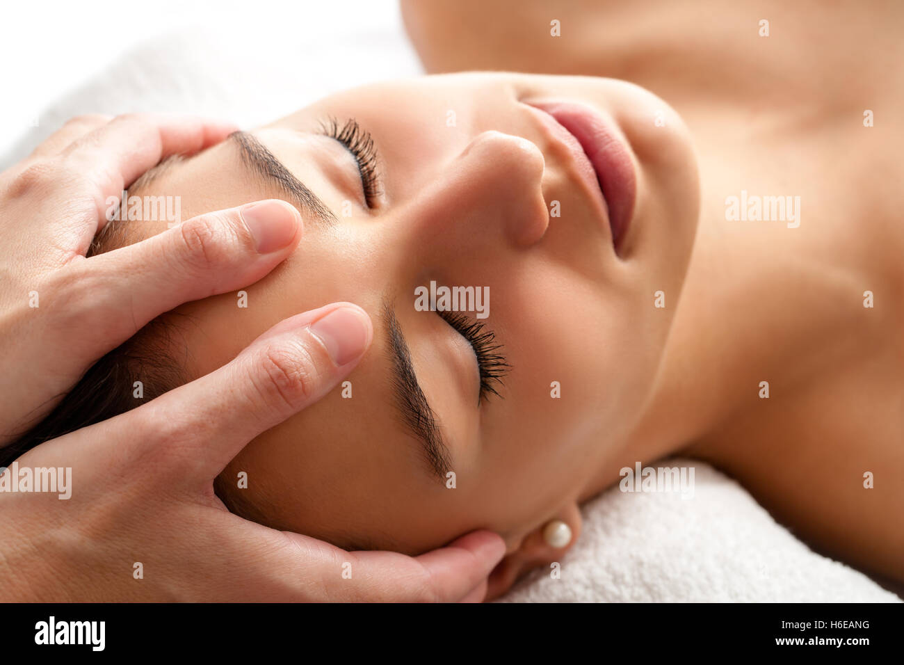 Close up head shot of Woman having massage du visage soins curatifs. Thérapeute en appliquant une pression avec les pouces sur le front. Banque D'Images