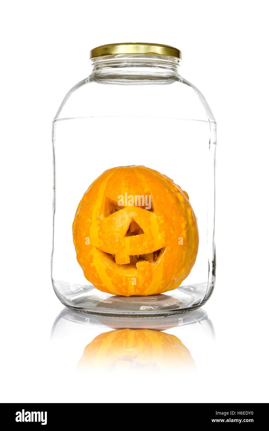 Halloween citrouille dans un bocal en verre isolé sur fond blanc Banque D'Images