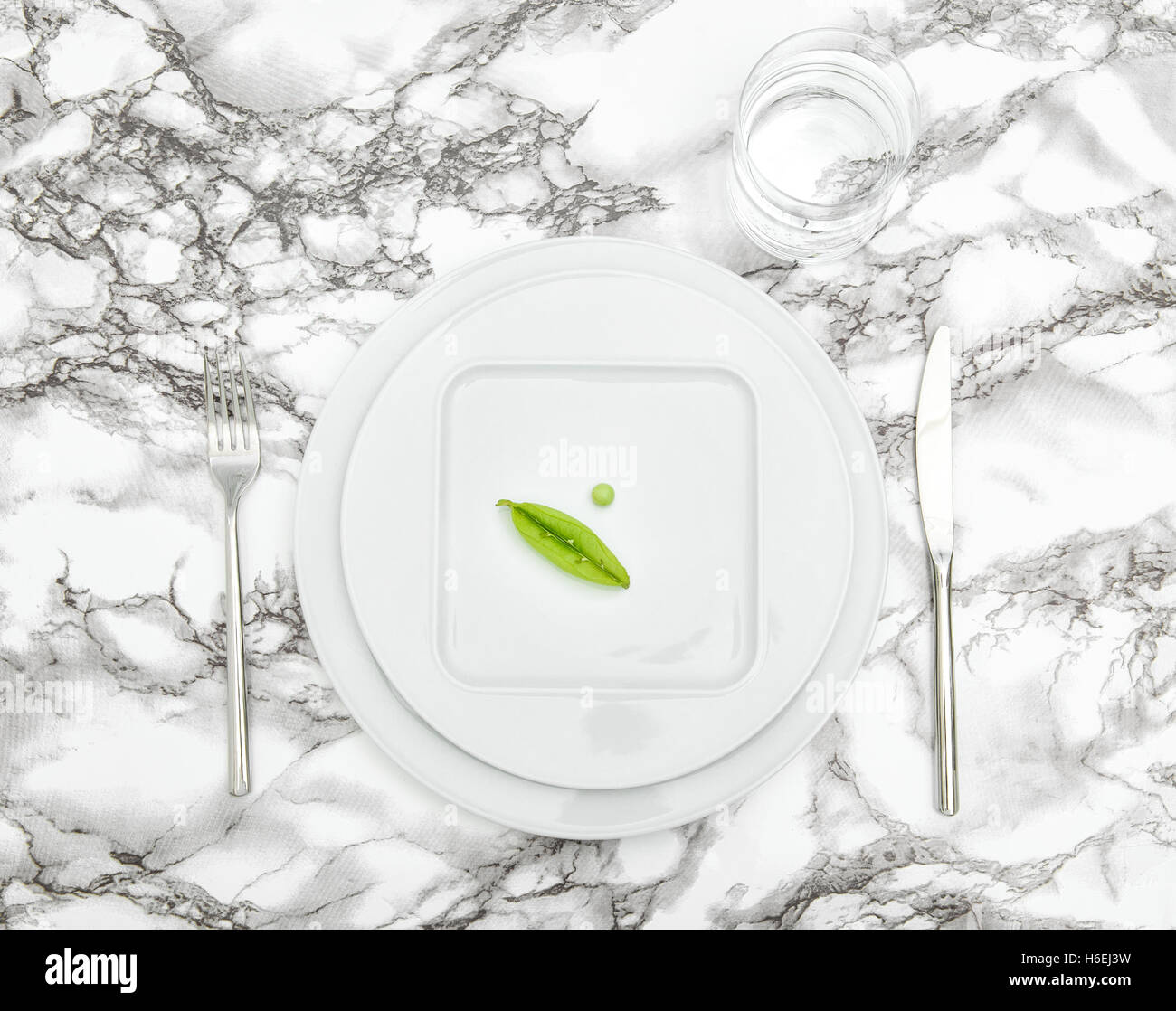 Réglage de la table avec de la vaisselle verre d'eau. Concept de régime. Le minimalisme de lay Banque D'Images
