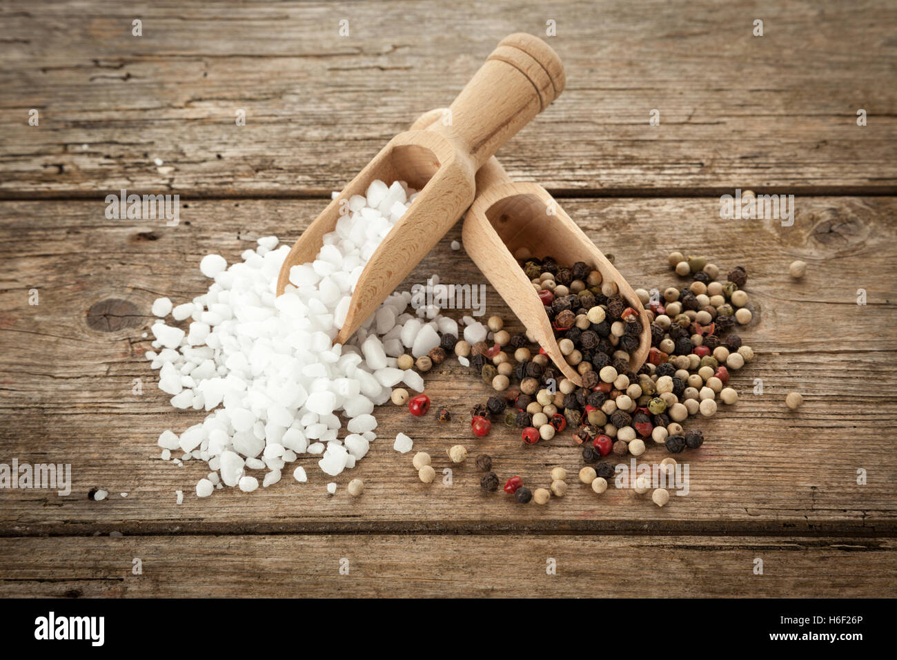 Gros-grain fin sel et poivre mélangés sur pelles en bois, sur la table rustique, high angle view Banque D'Images