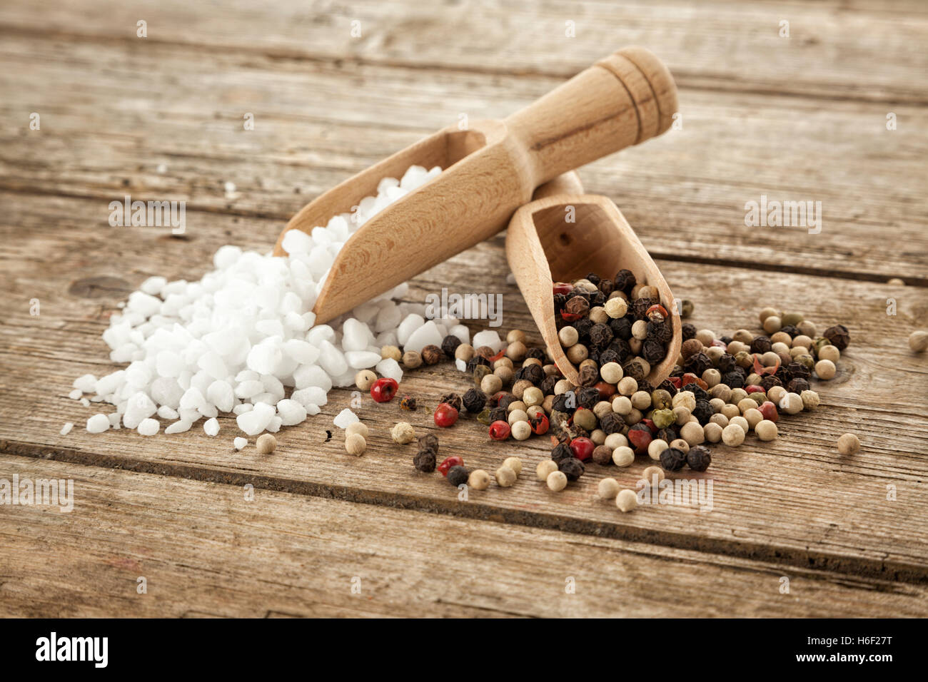 Gros-grain fin sel et poivre mélangés sur pelles en bois, sur table rustique Banque D'Images