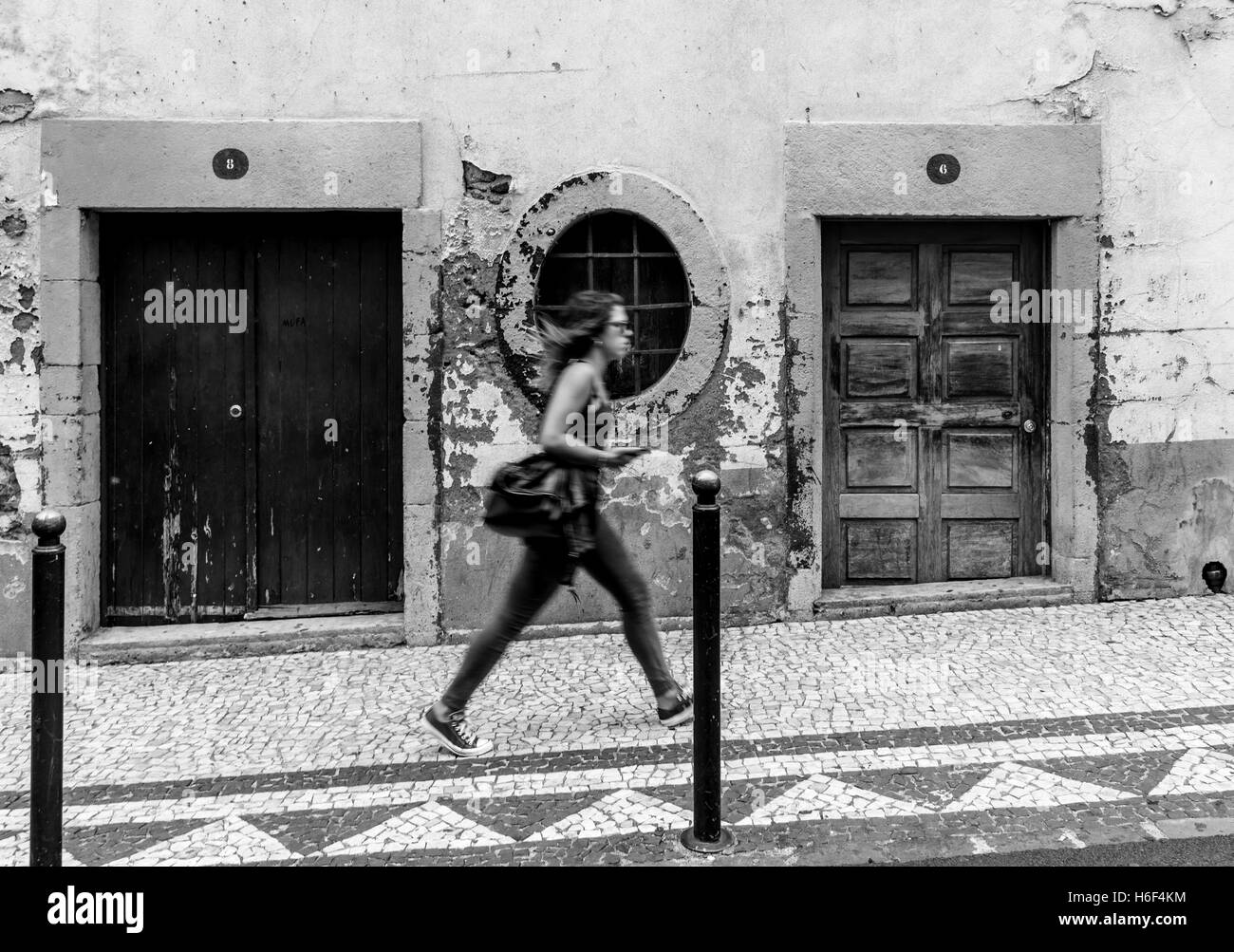 Jeune femme en passant devant l'ancien bâtiment/les embrasures à Funchal, Madère Banque D'Images