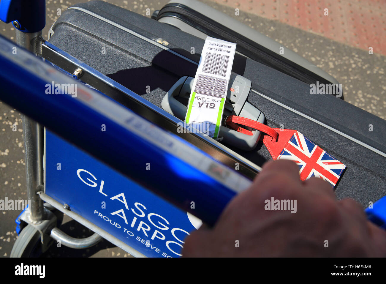 Poussant chariot à bagages à l'aéroport international de Glasgow, Écosse, Royaume-Uni Banque D'Images