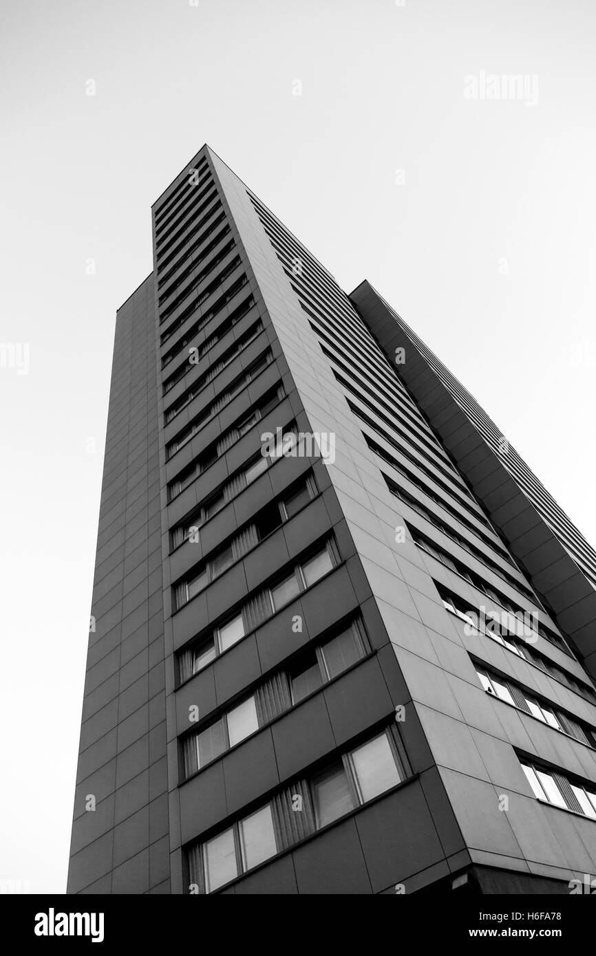 Low angle view of an apartment building éclairé par les premières lueurs du matin, avec un ciel clair derrière elle. Banque D'Images
