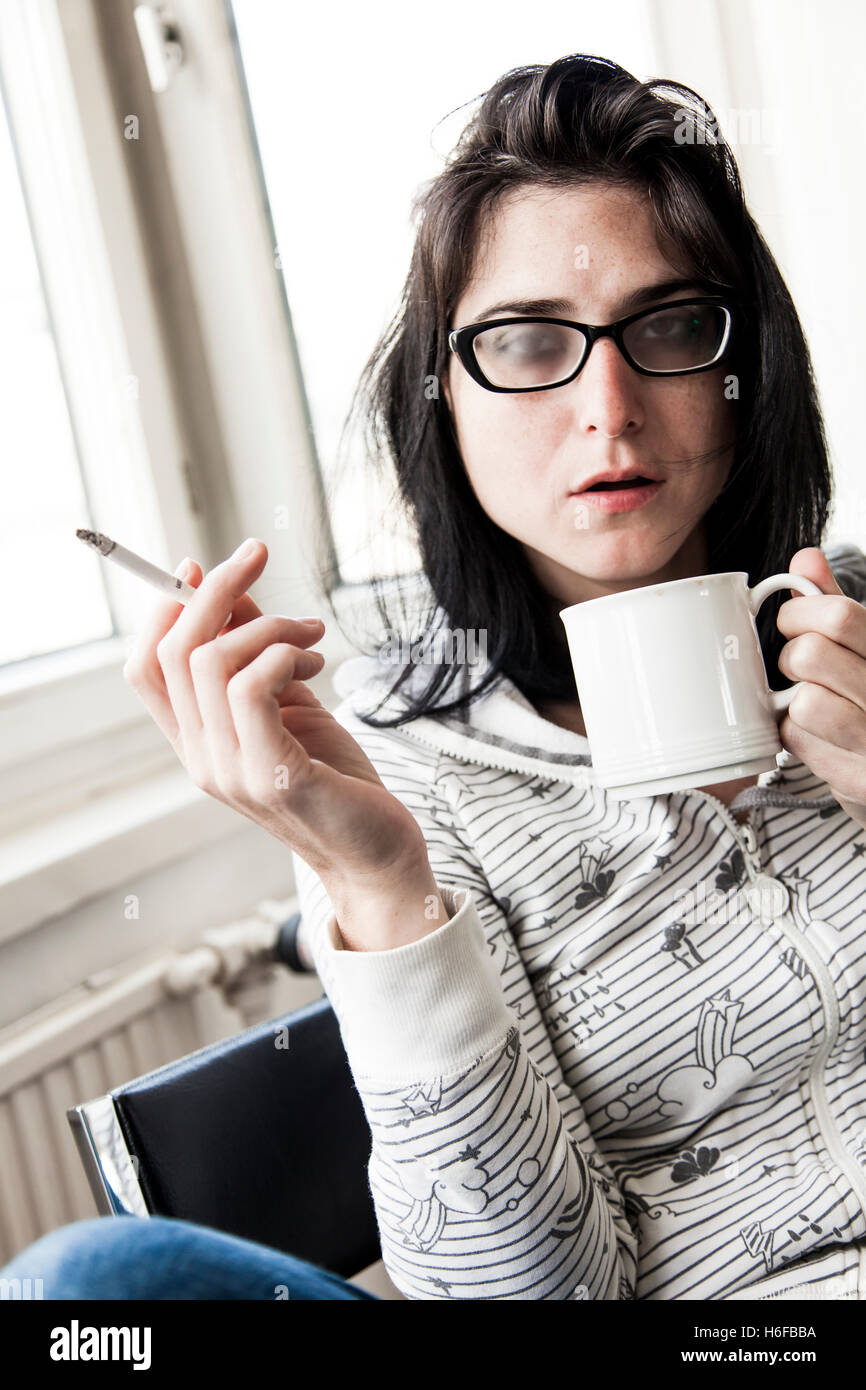 Une femme de boire son café du matin et fumer sa cigarette du matin. Très réaliste. Banque D'Images