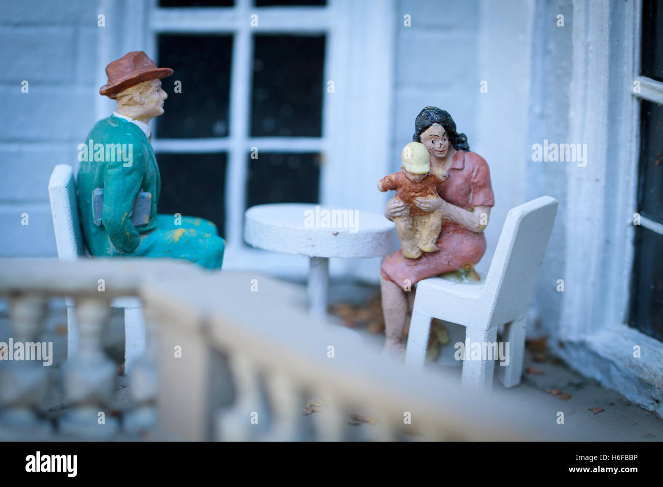 Petites figurines de famille assis sur un balcon. Banque D'Images