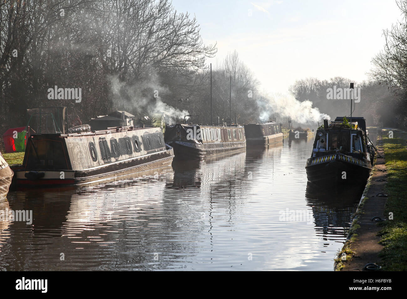 Fumée qui s'élève des bateaux étroits ou des barges lors d'une journée d'hiver froide à Norbury Junction Shropshire Union Canal Staffordshire Angleterre Banque D'Images