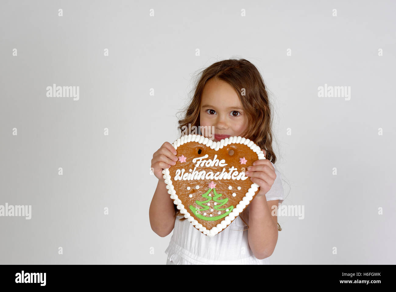 Enfant, Girl with gingerbread heart, frohe Weihnachten, joyeux Noël, Upper Bavaria, Bavaria, Germany Banque D'Images