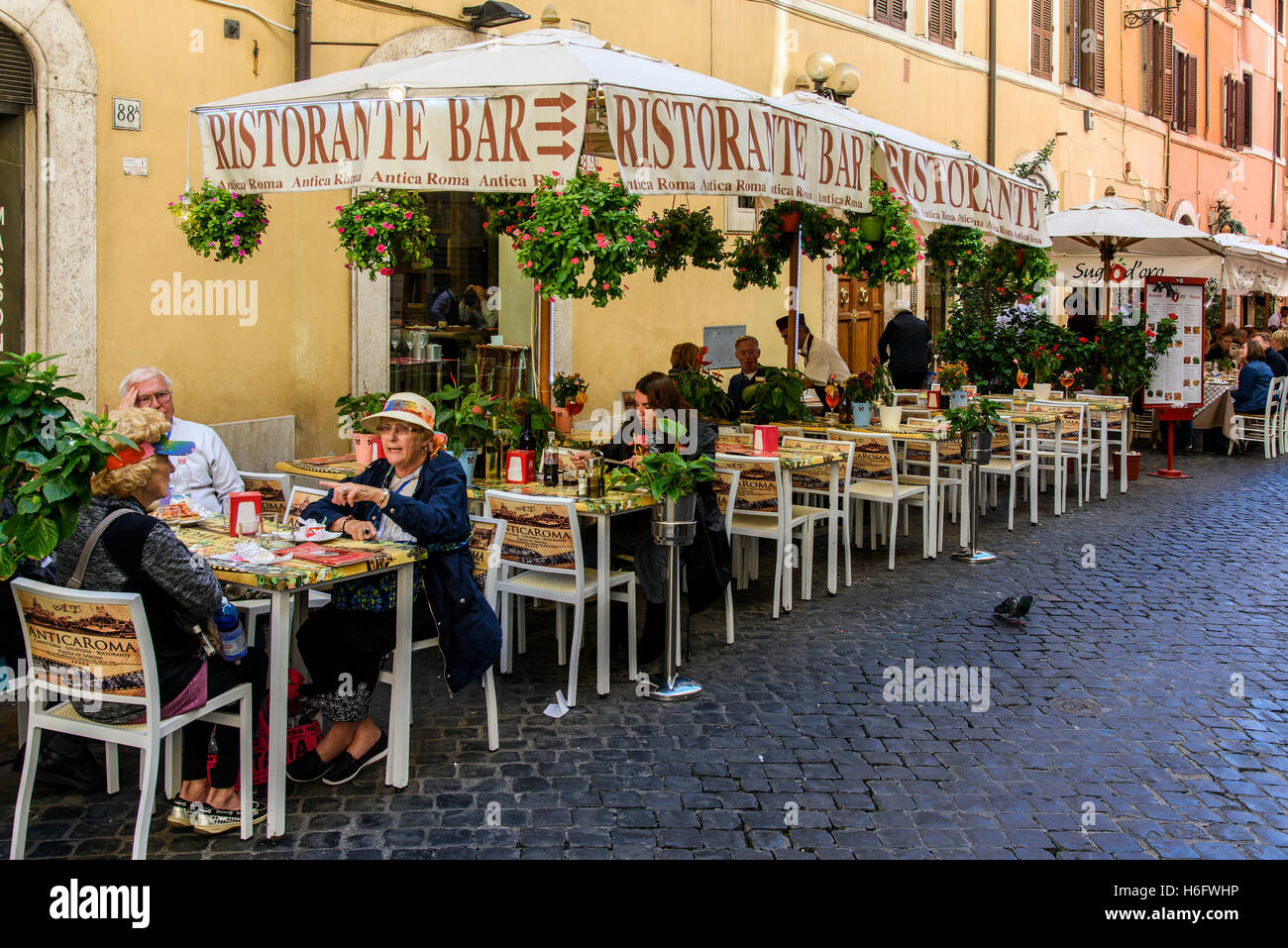 Les touristes assis à des tables à l'extérieur d'un restaurant-pizzeria de Rome, Latium, Italie Banque D'Images