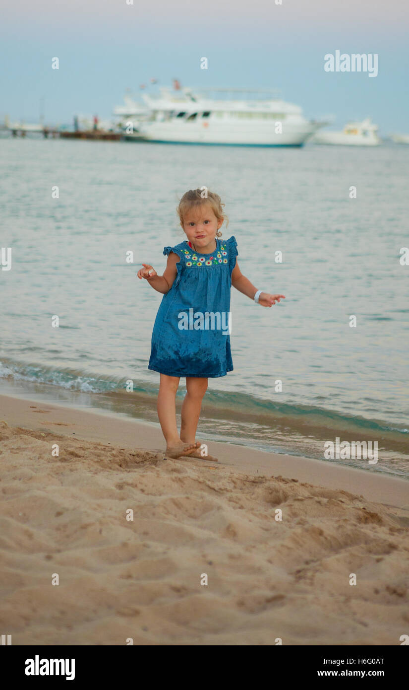 Jolie petite jeune fille posant sur la côte de la mer Banque D'Images