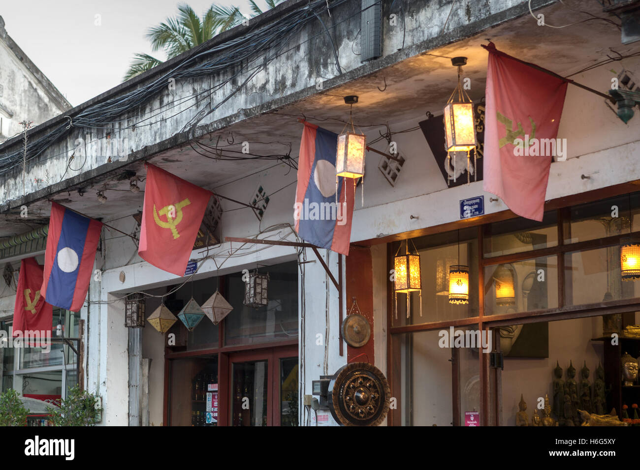 Drapeaux nationaux et communistes, bâtiments coloniaux français, magasins de rue principaux, Luang Prabang, Laos Banque D'Images