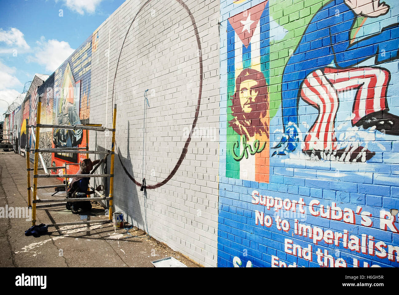 Artiste Danny Devenney prépare un mur d'une nouvelle fresque sur le mur de la paix internationale, Falls Road, Belfast. Banque D'Images