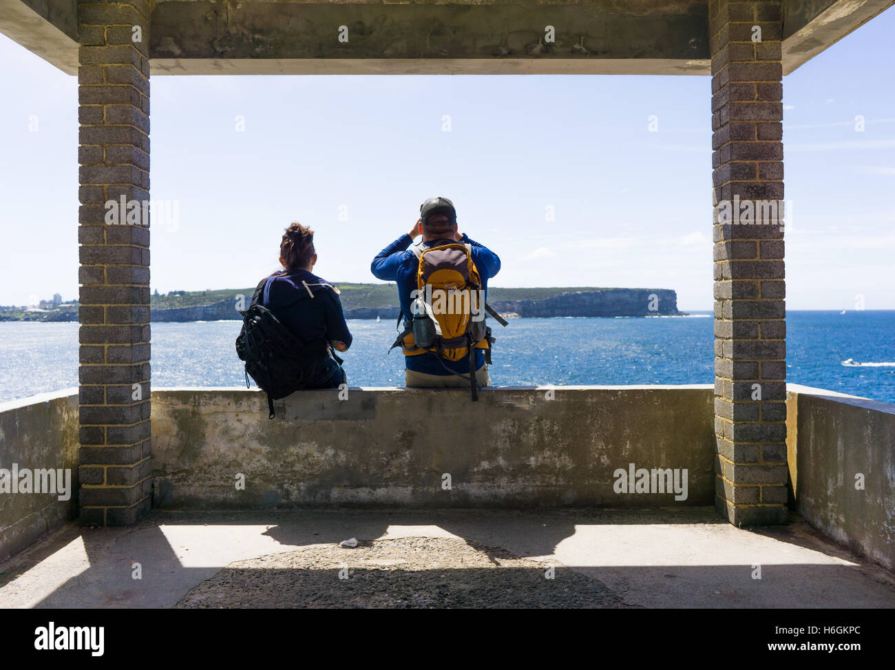 Un couple marche prendre une pause pour regarder la vue. Photographié à la tête du Sud, Sydney. Banque D'Images