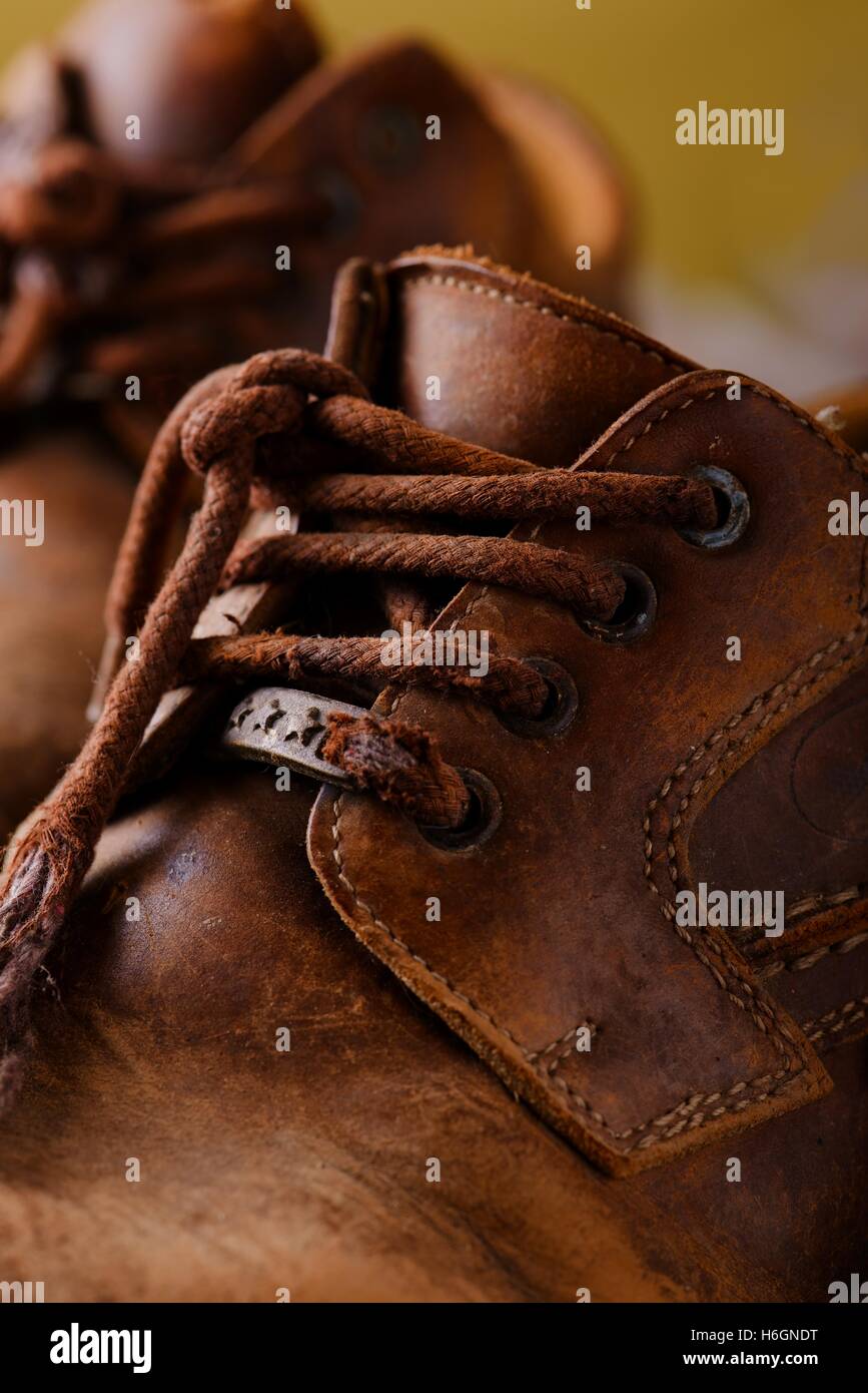 Photo verticale avec détail des très vieux et usé lacets qui sont placés sur de vieilles bottes en cuir. Banque D'Images