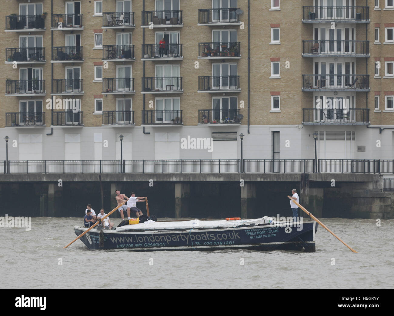 Des équipes d'apprentis qui suivent dans la barge de la Tamise à Greenwich de course conduite Westminster Bridge, Londres. Banque D'Images