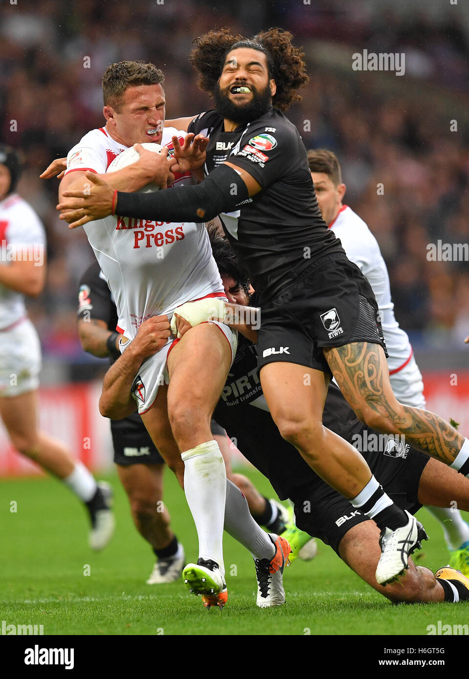 L'Angleterre Sam Burgess est abordé par l'Adam Blair lors de la Ladbrokes Quatre Nations match à la John Smith's Stadium, Huddersfield. Banque D'Images