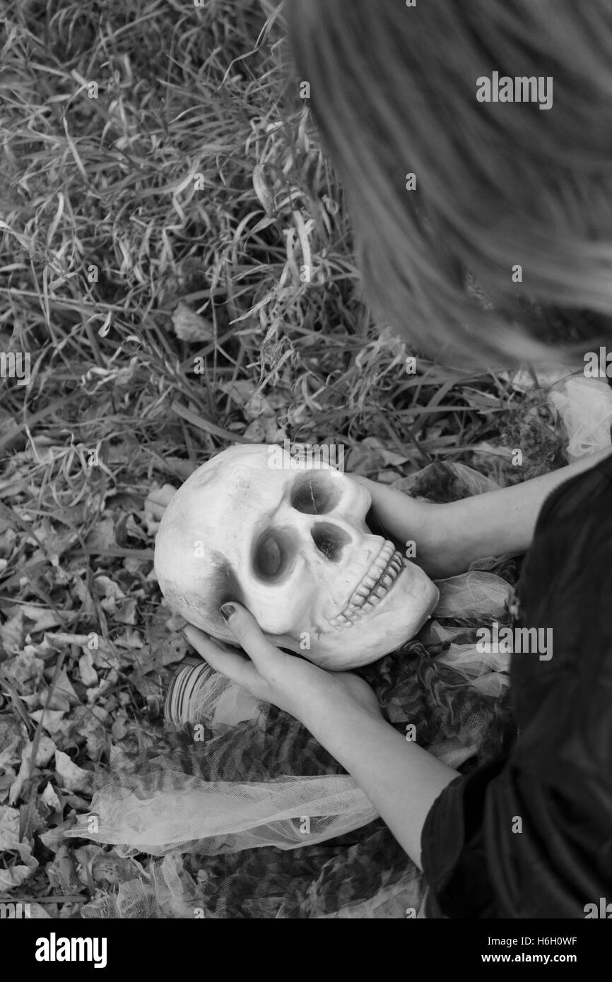 Photo noir et blanc de l'enfant seul dans la région de forest holding skull Banque D'Images