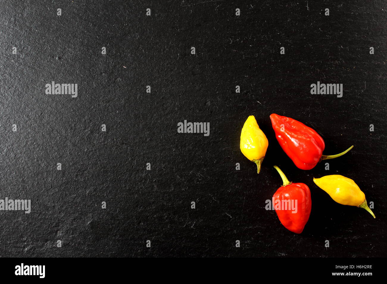 Jaune et rouge piment fantôme sur une plaque en ardoise Banque D'Images
