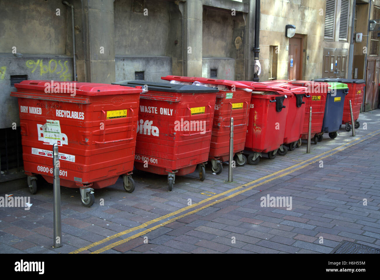Old red ligne bennes poubelles en alley lignes jaunes Banque D'Images