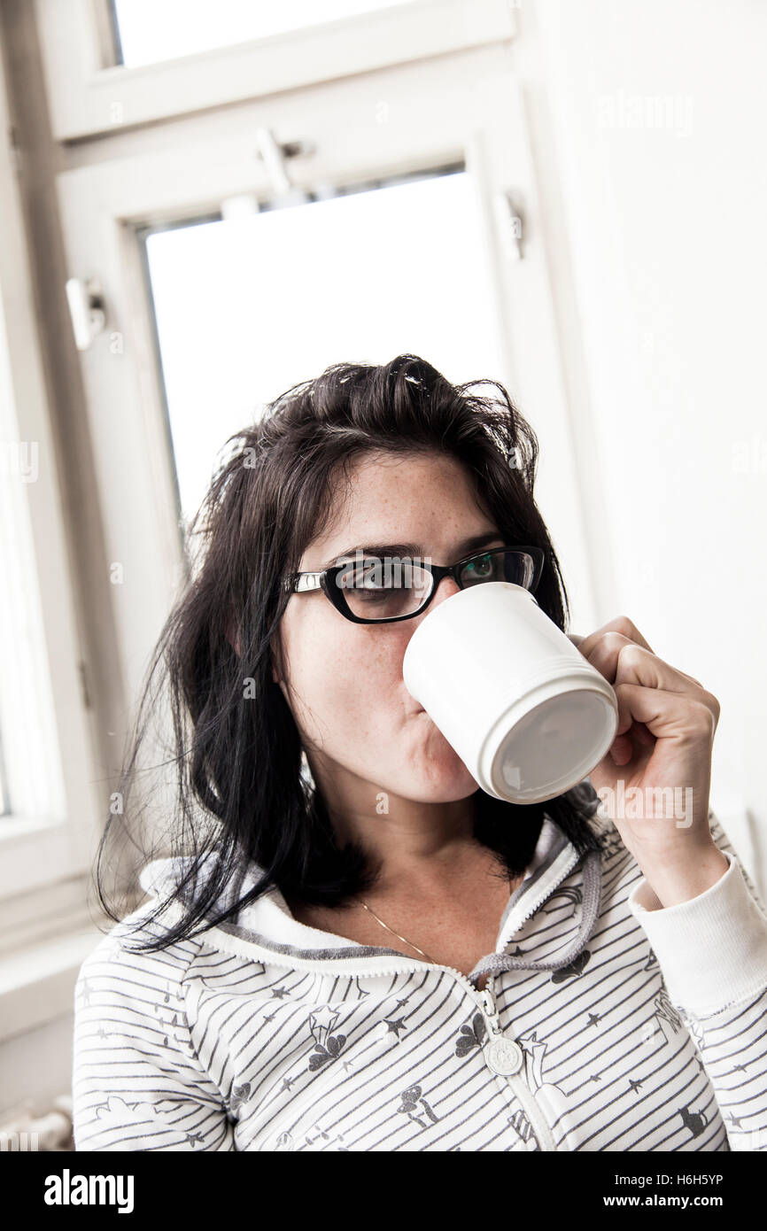 Une femme de boire son café du matin et fumer sa cigarette du matin. Très réaliste. Banque D'Images