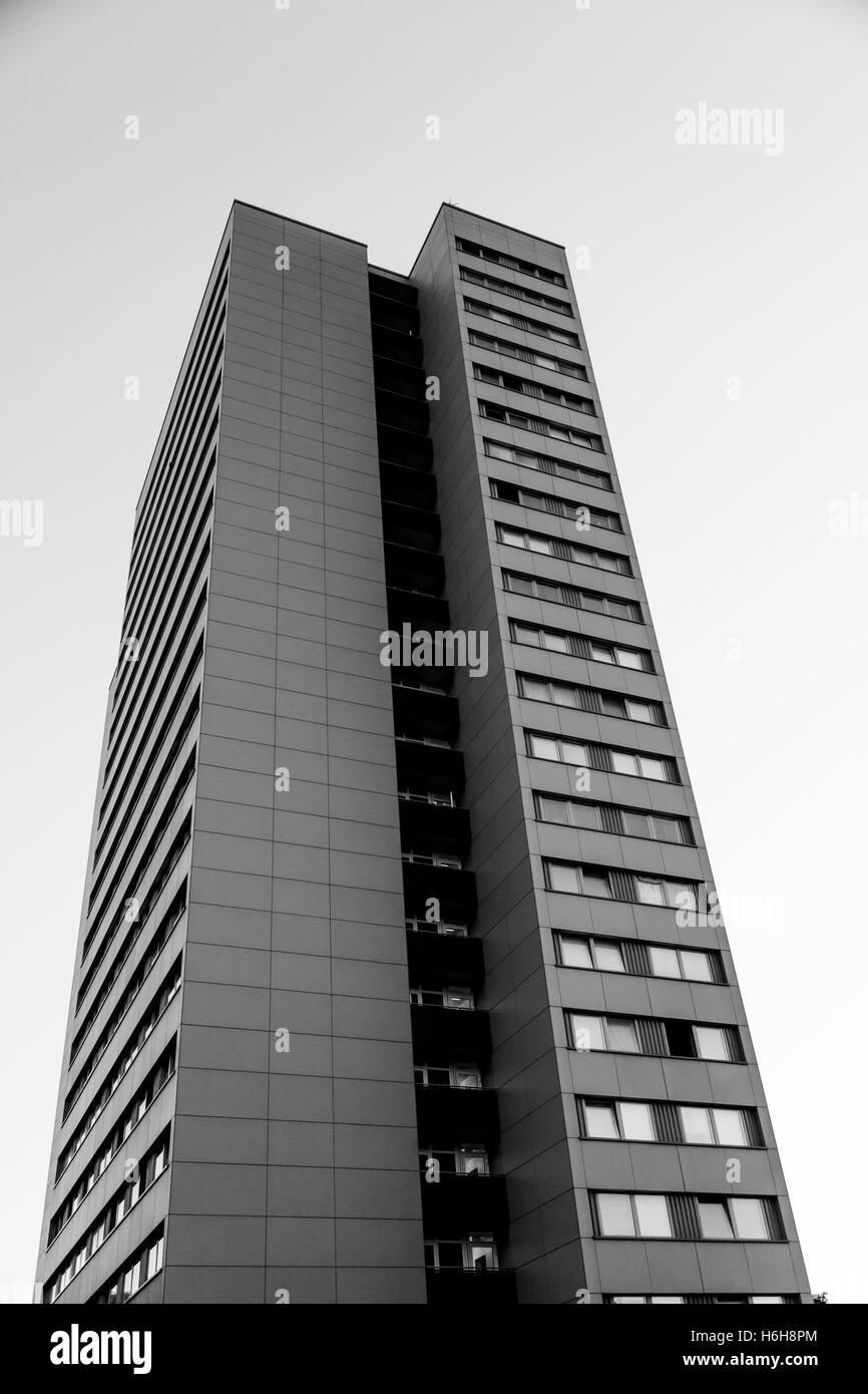 Low angle view of an apartment building éclairé par les premières lueurs du matin, avec un ciel clair derrière elle. Banque D'Images