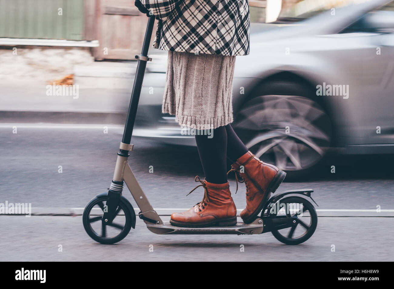 Fille dans des vêtements décontractés sur scooter de coup on city street. Effet vintage rétro Instagram tonique Banque D'Images