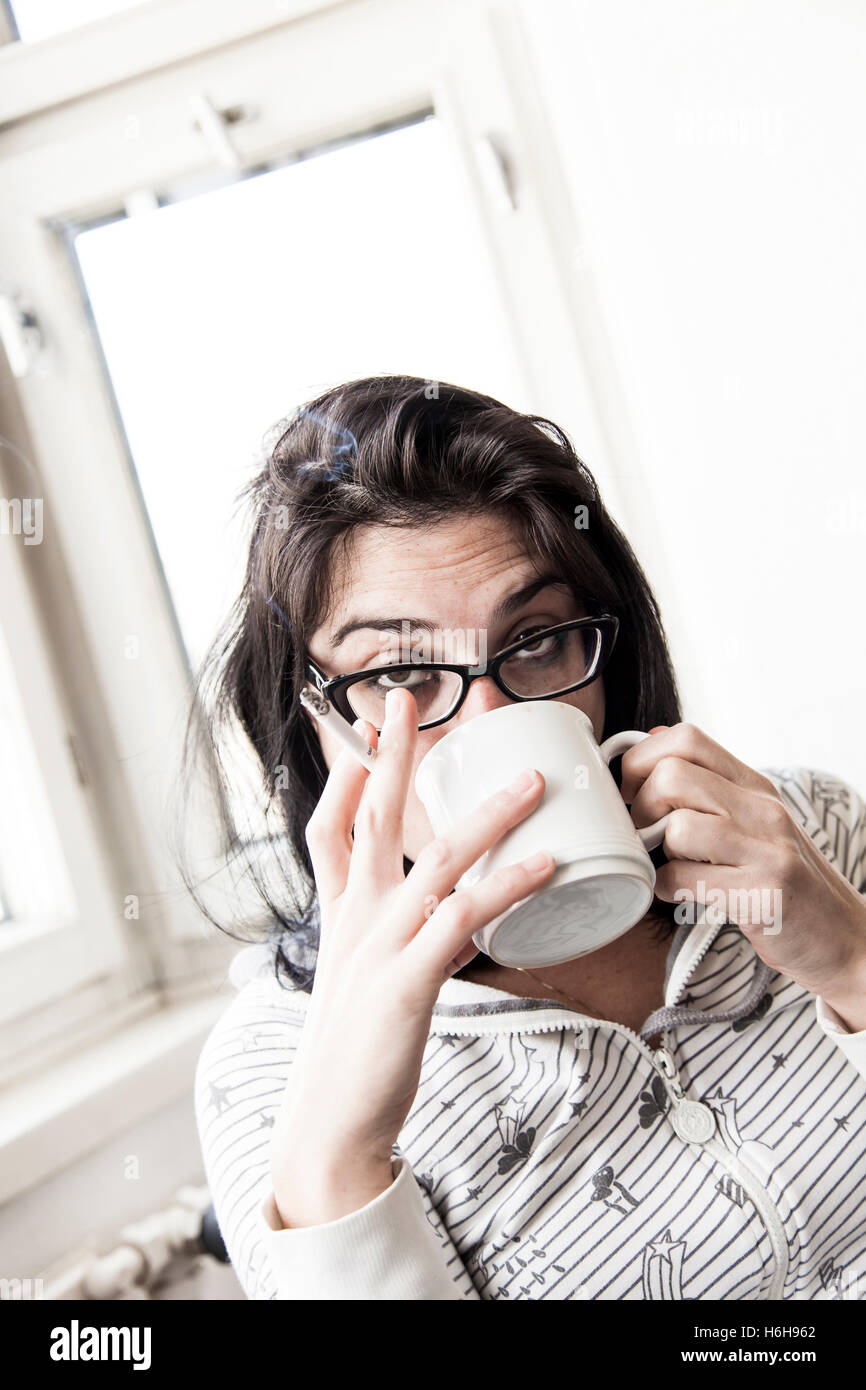 Une femme de boire son café du matin et fumer sa cigarette du matin. Très réaliste. Banque D'Images