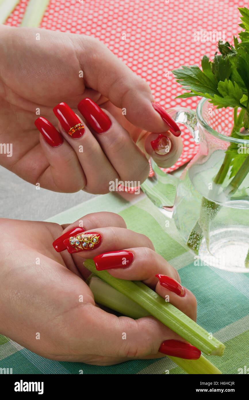 Les mains des femmes avec une manucure et verts de l'eau pot Banque D'Images