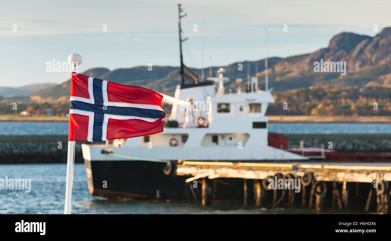 Brandir le drapeau norvégien sur les garde-corps de navire dans le port de Brekstad, la Norvège. Vintage photo stylisée avec correction tonale Banque D'Images