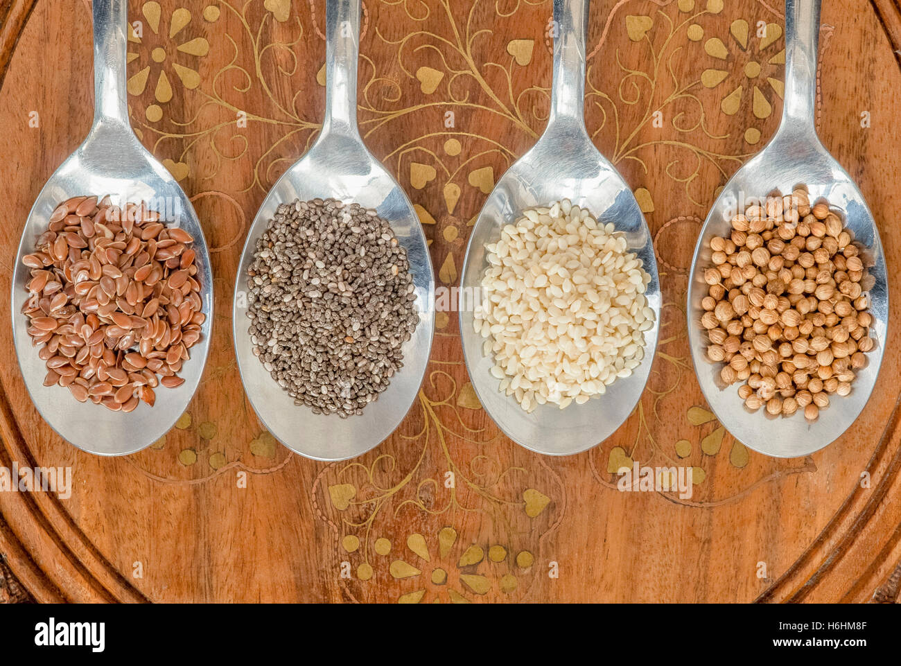 Quatre grains dans quatre cuillères ensemble sur une table en bois, doublée en une ligne, en plongée des Banque D'Images