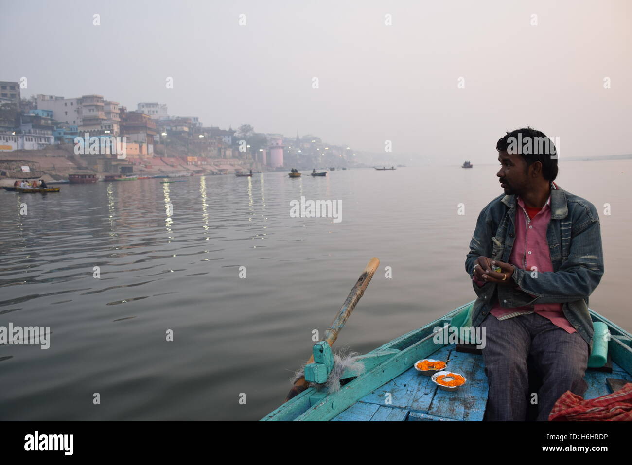 Batelier indien sur son bateau sur le Gange au lever du soleil, Varanasi, Uttar Pradesh, Inde Banque D'Images