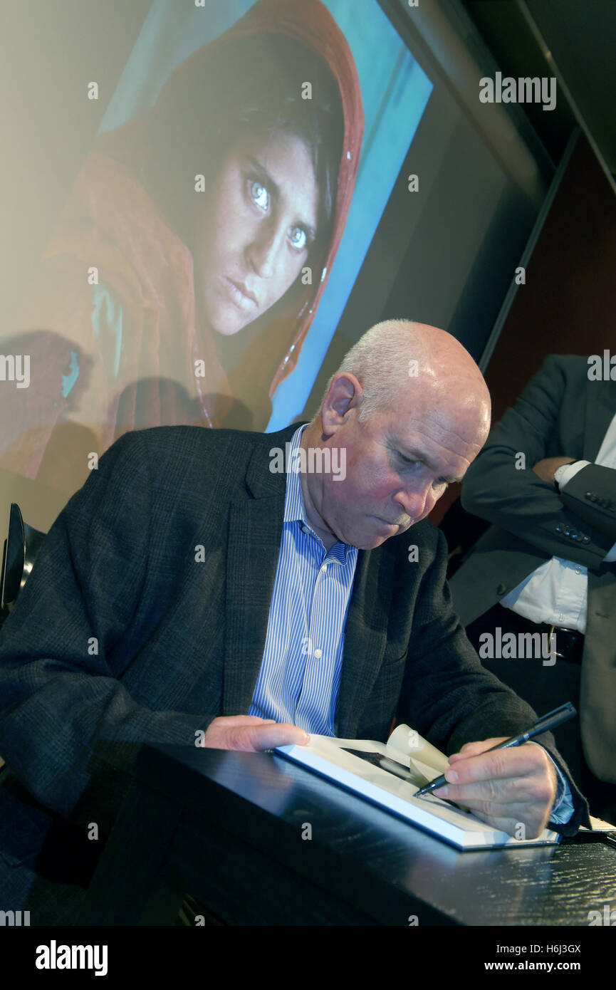 Munich, Allemagne. 28 Oct, 2016. Steve McCurry, photographe nous signe ses livres après son 'événement sur la lecture. Une passion sans frontières' dans la Literaturhaus à Munich, Allemagne, 28 octobre 2016. Dans l'arrière-plan sur l'écran est l'un de ses plus célèbres photos d'une fille afghane, qui a été la couverture de National Geographic. Photo : FELIX/HOERHAGER dpa - PAS DE FIL - SERVICE/dpa/Alamy Live News Banque D'Images