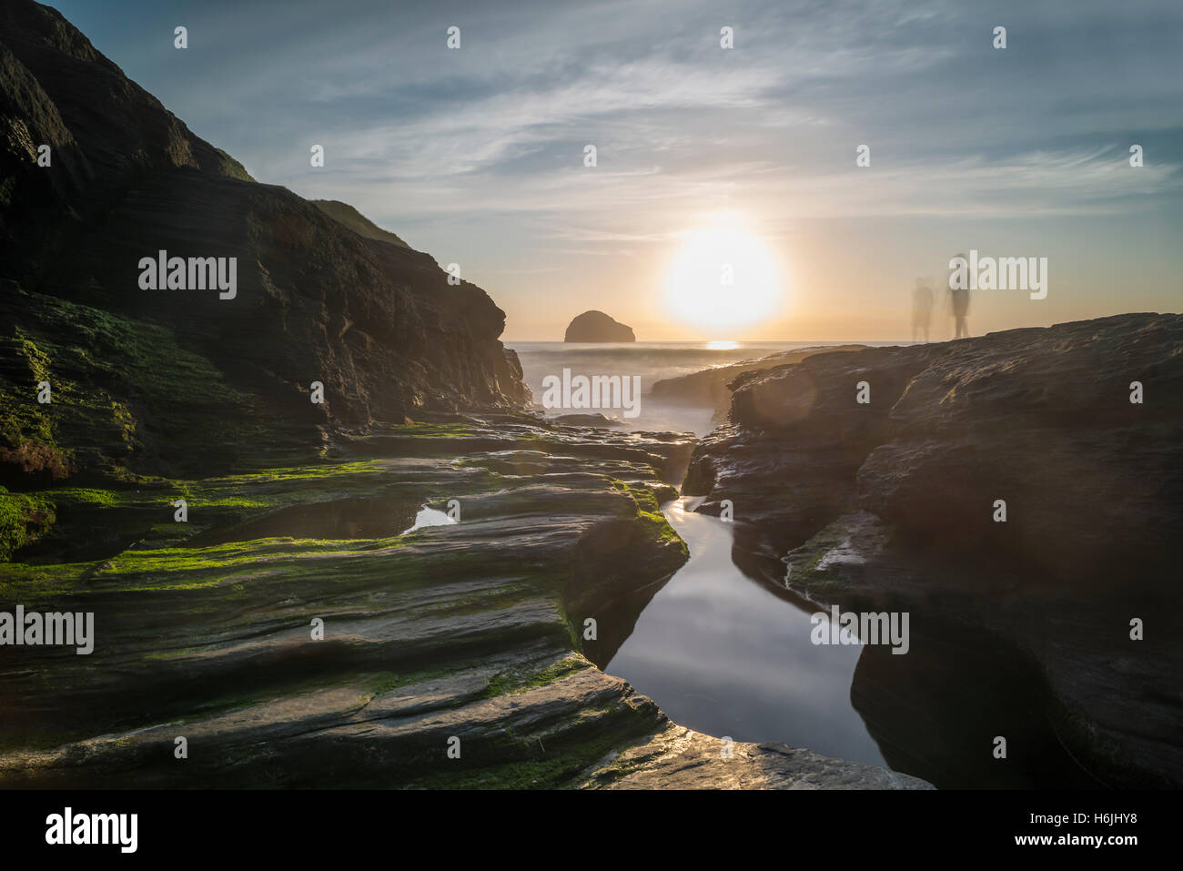 Côte Rocheuse et Océan surf, des flaques d'eau et d'ardoise,des pierres sur la baie à la plage de Trebarwith près de Tintagel face au soleil du soir lumineux, Cornwall, UK Banque D'Images