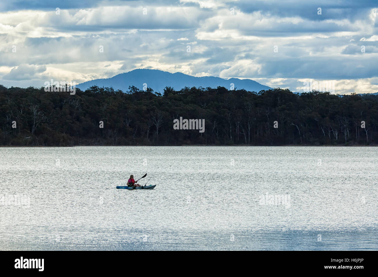 Personne kayak et la pêche sur le lac Wallaga dans la soirée, près de Bermagui, New South Wales, NSW, Australie Banque D'Images