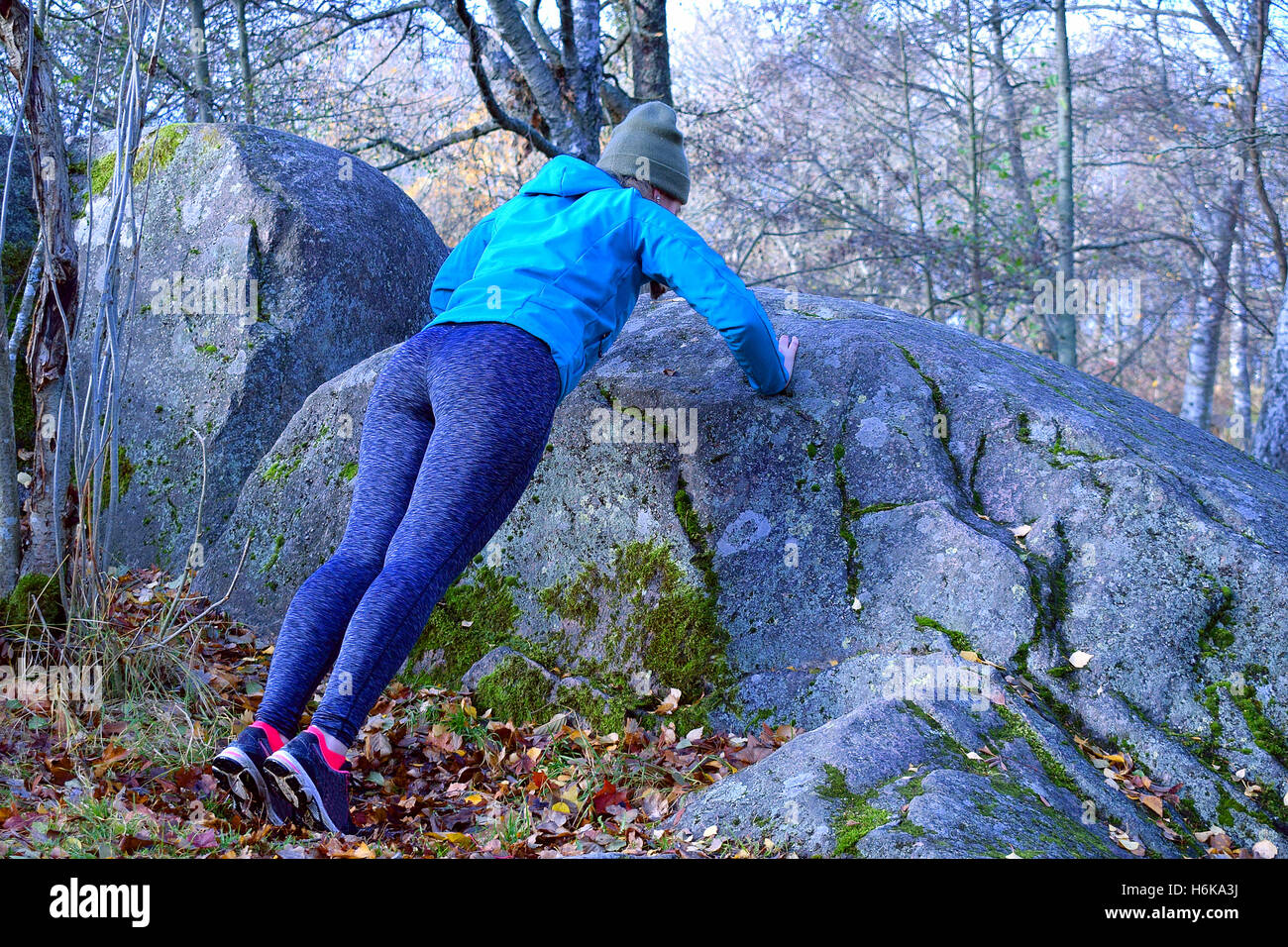 Femme travaillant dans la forêt. Faire poussez se lève à l'encontre de big rock. Banque D'Images