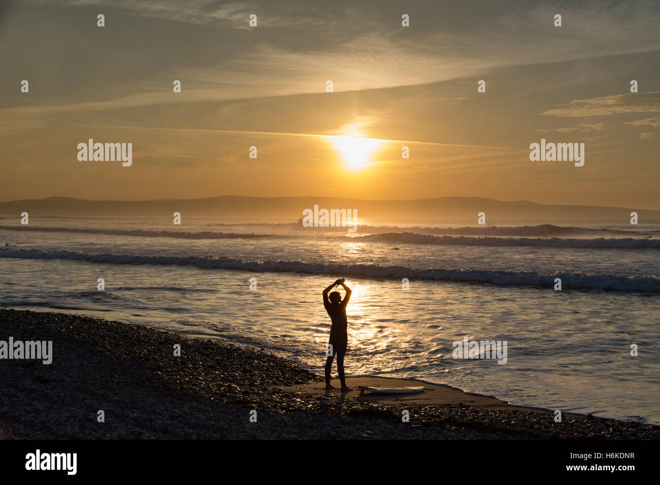 Gwithian, Cornwall, UK. 30e Cotober 2016. Météo britannique. Au coucher du soleil avec des températures de 17 degrés C, les surfeurs et promeneurs de chiens profiter de la mer au coucher du soleil. Crédit : Simon Maycock/Alamy Live News Banque D'Images