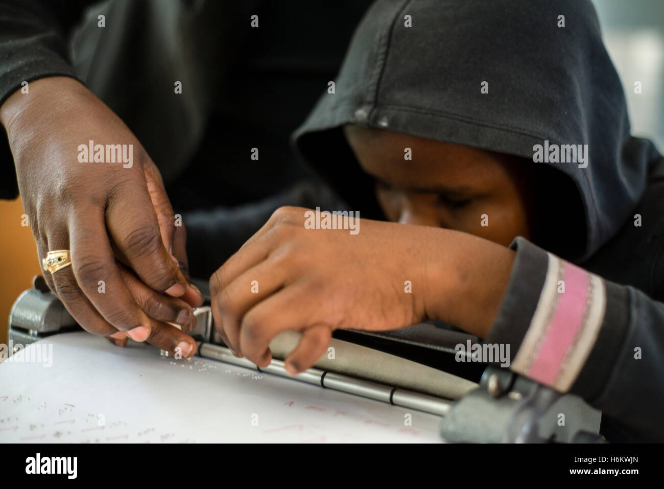 L'enseignant aide l'Washinana Esther apprenant malvoyants d'utiliser la machine à écrire en braille au cours de l'anglais au cours de l'école spéciale Eluwa à Windhoek, Namibie. Banque D'Images