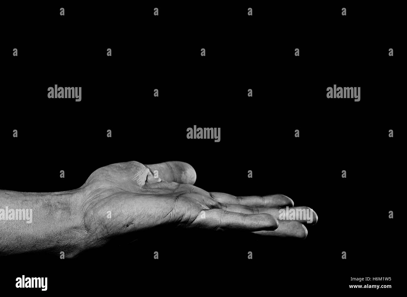 Communiqués paume vers le haut la main sale sur un fond sombre. Banque D'Images